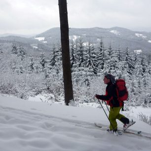 Po zelené turistické značce, na pozadí je vrchol Koncová
