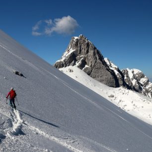 Místy byl sníh už rozbředlý - v pozadí Kotova špica (2376 m). Skialpinistická túra nad Kotovo sedlo pod severními srázy Jalovce v Julských Alpách.