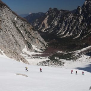 Pohled zpátky do doliny Planica. Skialpinistická túra nad Kotovo sedlo pod severními srázy Jalovce v Julských Alpách.