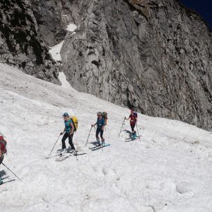 Traverz starého laviniště při průstupu dolinou. Skialpinistická túra nad Kotovo sedlo pod severními srázy Jalovce v Julských Alpách.
