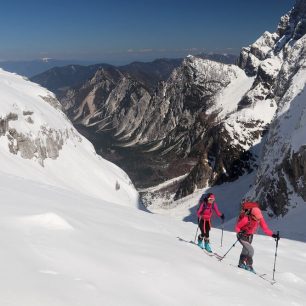 Vzadu je vidět hraniční hřeben s Rakouskem. Skialpinistická túra nad Kotovo sedlo pod severními srázy Jalovce v Julských Alpách.