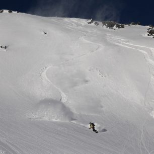 Sjezd splitboardisty mezi dvěma splazy uvolněnými skialpinisty