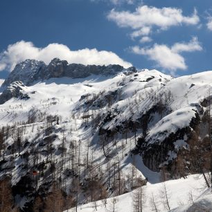 Výhled od dolní části skalní stěny na lyžařské středisko s kabinkovou lanovkou