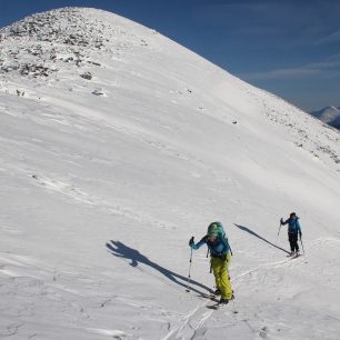 Splitboardiska a skialpinistka stoupající na vyfoukaný sibiřský hřeben
