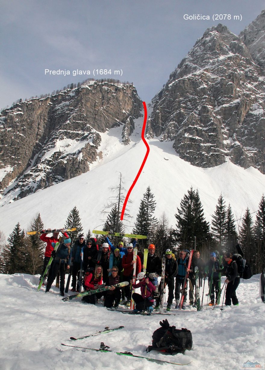 Skupinka lyžníků s nákresem výstupové a sjezdové trasy z grapy mezi dvěma vrcholy