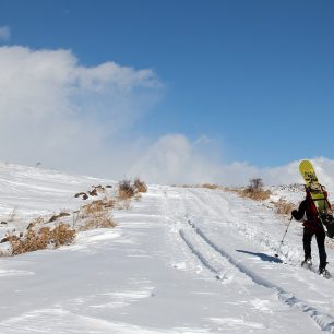 Na sněžnicích se snowboardem na zádech směr Aragats