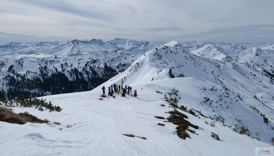 Skialpinisticko-splitboardová skupinka na hřebenu s Plannereckem (2003 m) v pozadí