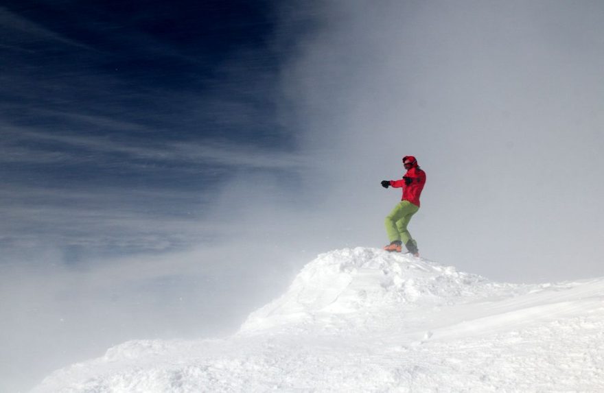 Matúš předvádí, jak by v silném větru kitoval - ty šmouhy v modré obloze je letící sníh