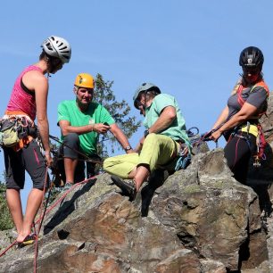 Genderově vyvážená skupina na vrcholu skály - dva horští vůdci a dvě frekventantky