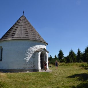 Běloskvoucí rotunda Kunštátské kaple na hřebeni Orlických hor.